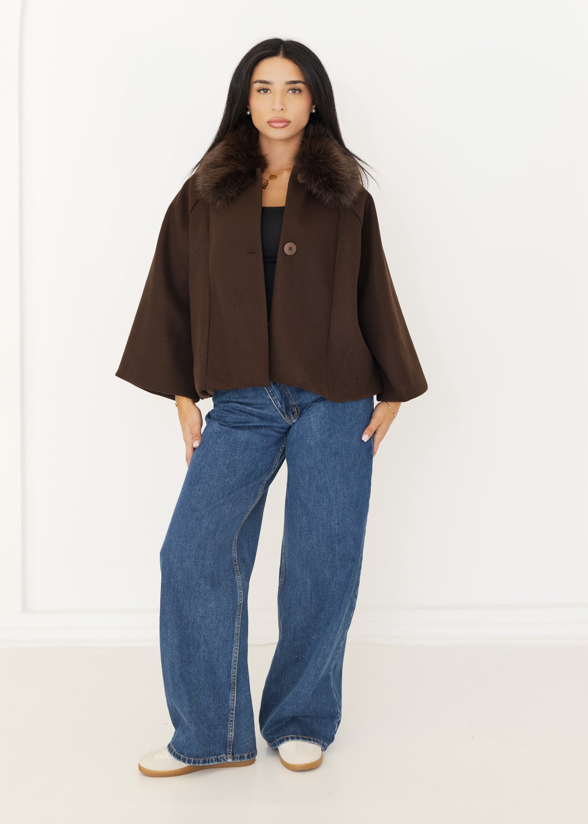 Damen Cape-Jacke in Braun mit Fellkragen, offen getragen zu blauer Wide-Leg-Jeans