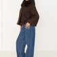 Seitenansicht der braunen Cape-Jacke mit Fellkragen, cropped Länge und Oversize-Ärmeln