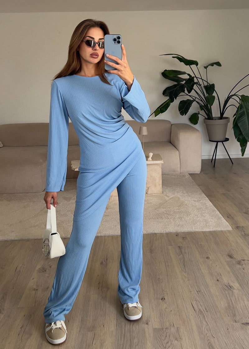 Modell trägt ein hellblaues Casual Chic Set mit asymmetrischer Tunika und lockerer Hose – perfekter Look für Alltag und Urlaub