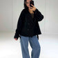 Schwarzer kurzer Trenchcoat offen getragen über braunem Top, Oversize-Look