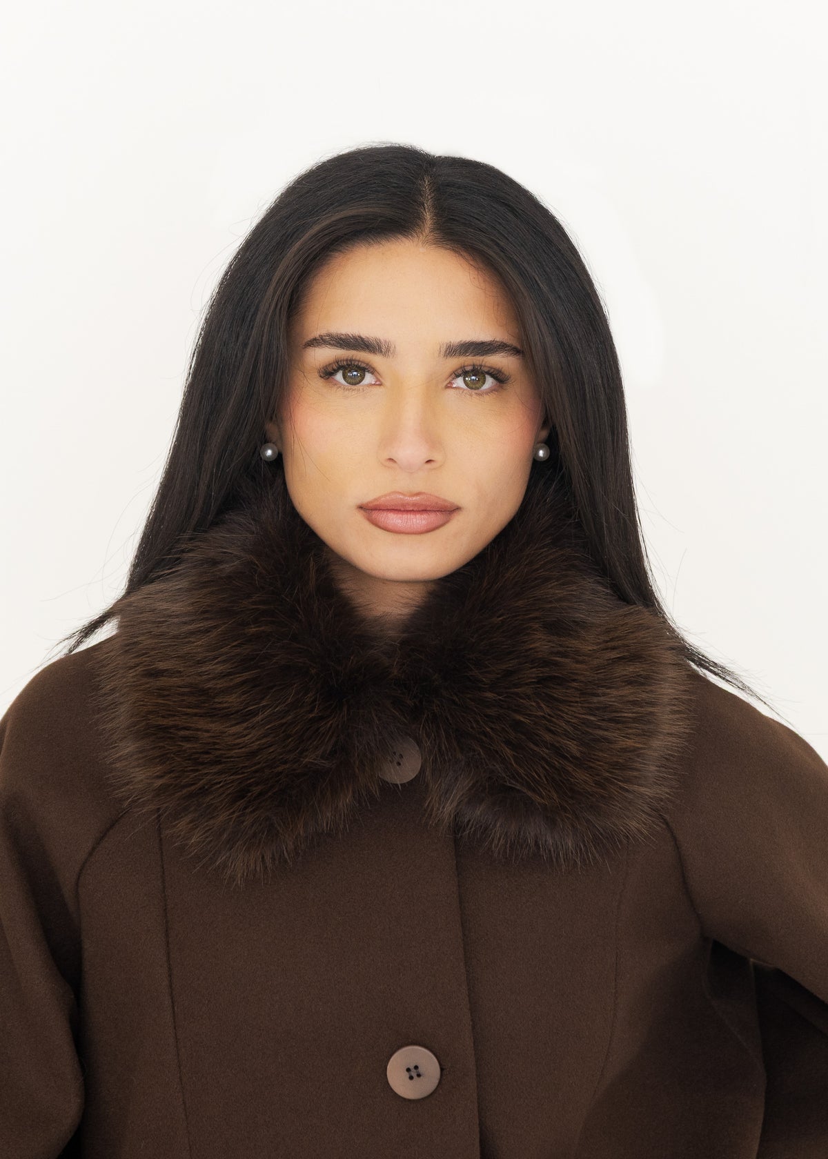Nahaufnahme der Jacke mit Fellkragen in Braun, Old-Money-Look mit Perlenohrringen