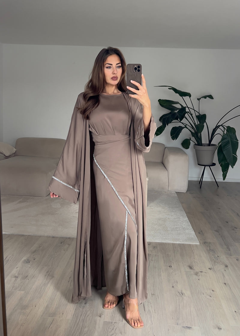 Modell trägt ein zweiteiliges Kaftankleid in Taupe mit Wickelrock und lockerem Oberteil – stilvoll und elegant kombiniert