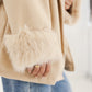 Detailansicht der flauschigen Kunstfell-Manschette am Ärmel der beigen Wickeljacke