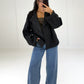 Frau in kurzem schwarzem Zweireiher-Mantel in Woll-Optik zu Wide-Leg-Jeans, Vorderansicht