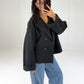 Frau in kurzem schwarzem Zweireiher-Mantel in Woll-Optik zu Wide-Leg-Jeans, Seitenansicht