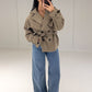 Frau in kurzem Trenchcoat in Taupe mit Bindegürtel zu Wide-Leg-Jeans, Vorderansicht