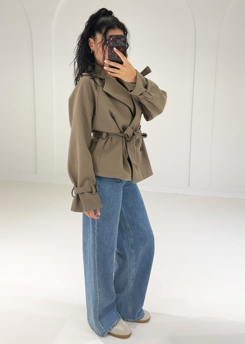 Seitenansicht: kurzer Trenchcoat in Taupe mit gebundenem Gürtel