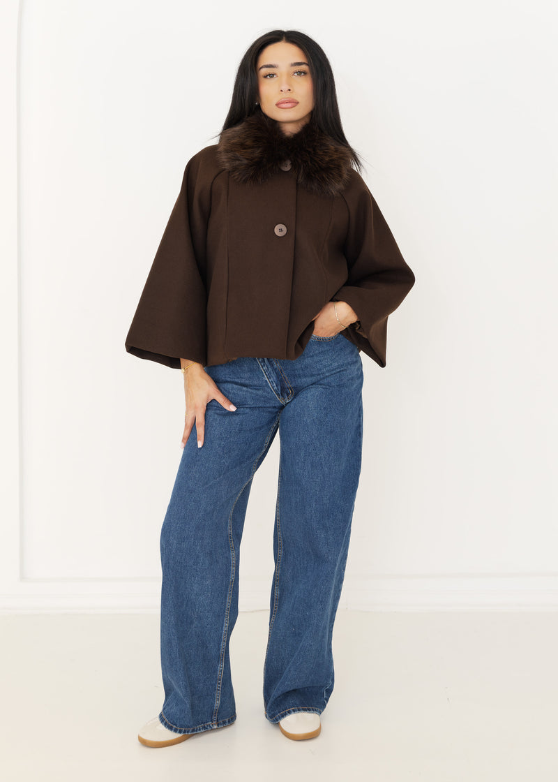Damen Cape-Jacke in Dunkelbraun mit Kunstfellkragen, geknöpft getragen zu blauer Wide-Leg-Jeans