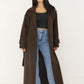 Offen getragener Oversize-Mantel in Dunkelbraun über schwarzem Top und blauer Wide-Leg-Jeans