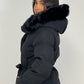 Modell trägt einen langen Damen Steppmantel mit Kapuze und Taillengürtel – NAHA Wintermode