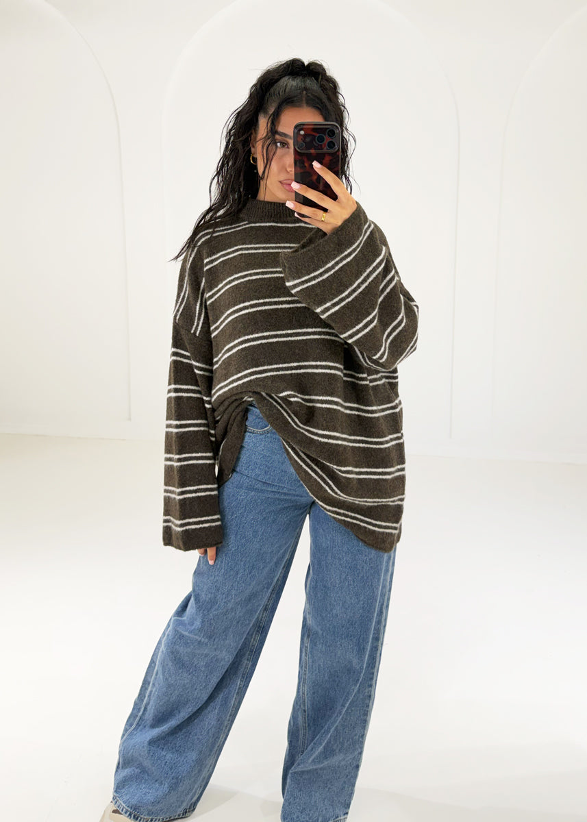 Brauner Streifenpullover locker vorne in die Jeans gesteckt, ganze Figur