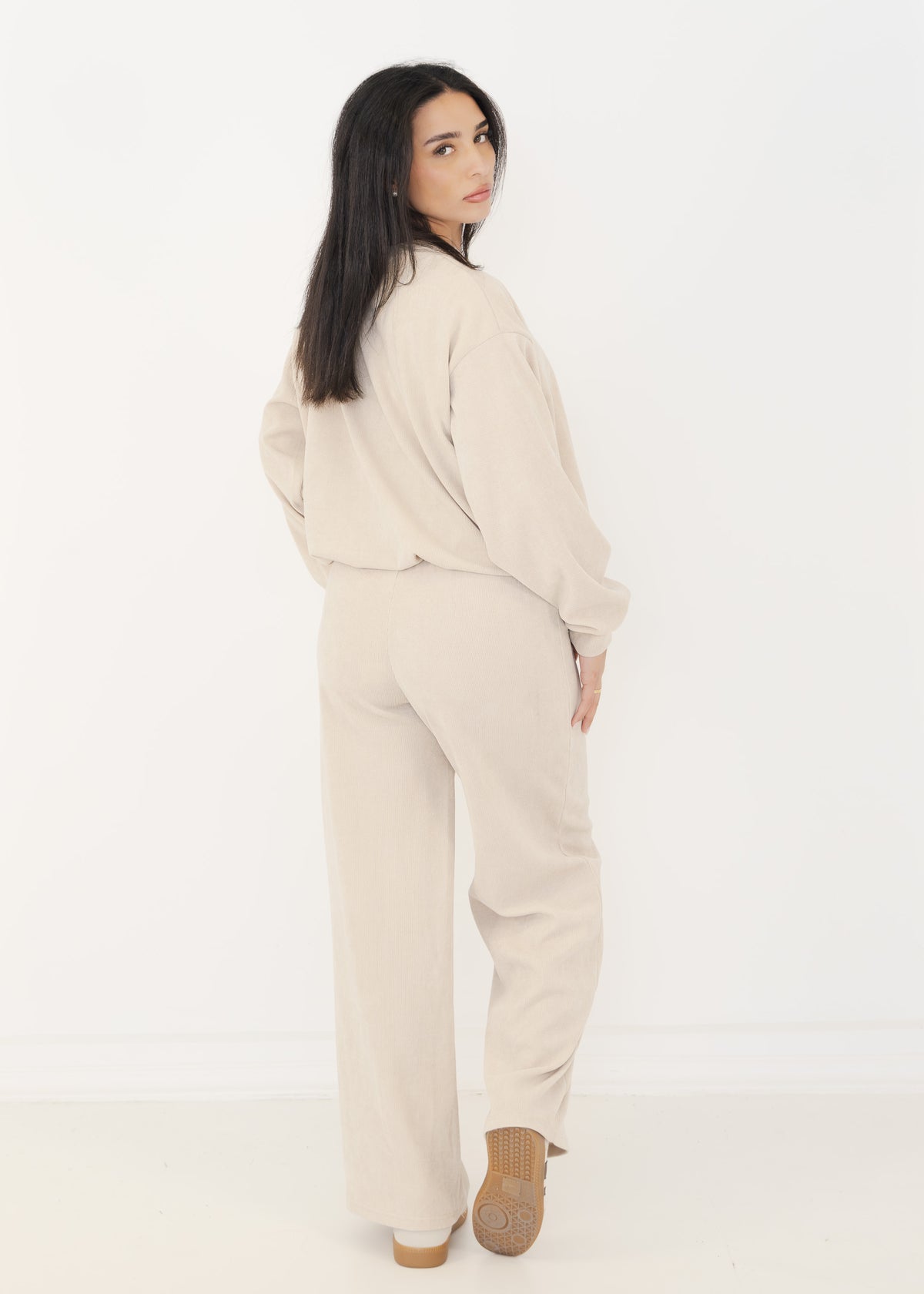 Rückansicht des Damen Strick-Zweiteilers in Beige mit weiter Strickhose