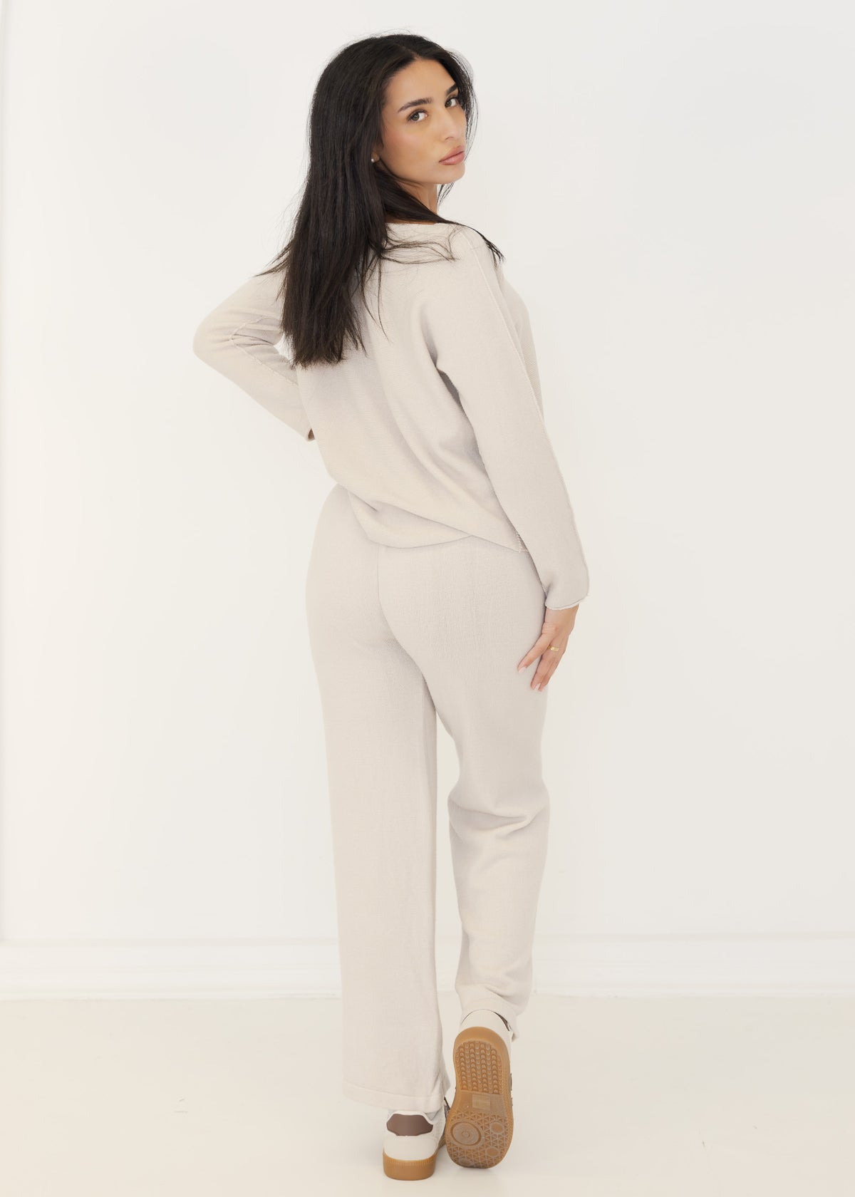 Rückansicht des Damen Strick-Zweiteilers in Beige mit weiter Strickhose