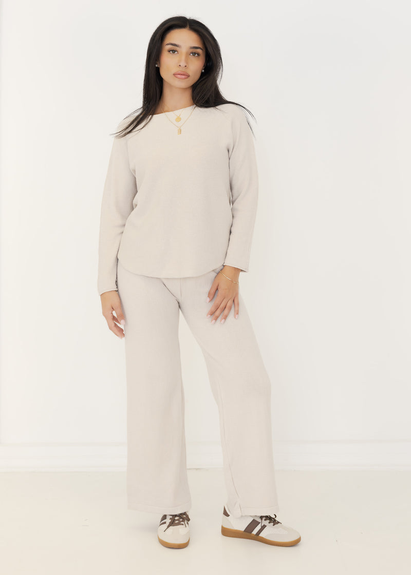 Damen Strick-Zweiteiler in Beige aus Pullover und weiter Strickhose, getragen mit Sneakern