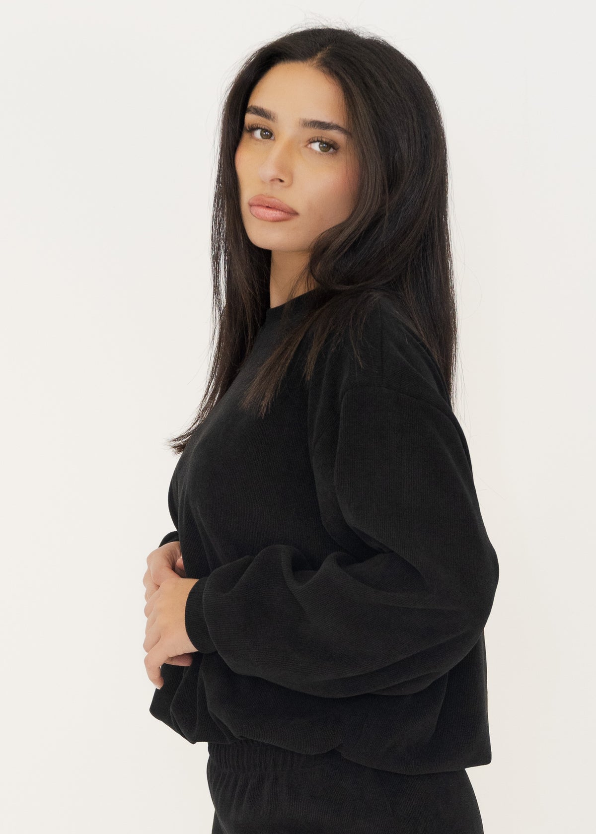 Nahaufnahme des schwarzen Strickpullovers kombiniert mit goldenen Halsketten